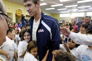 Michael Phelps surrounded by children white visiting the Boys and Girls Club of Burbank in California in September 2008