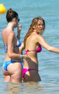 Bar Refaeli swimming at the beach with friend in a dark pink two-piece bikini