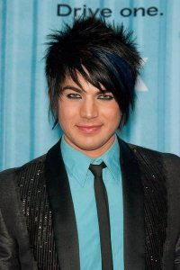 Adam Lambert blue shirt under a black suit jacket matched with a black neck tie