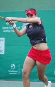 Sania Mirza during a tennis game in a red skirt