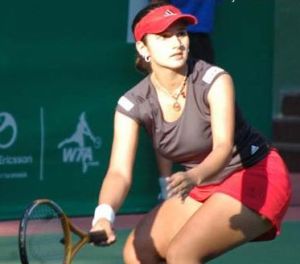 Sania Mirza during a tennis game in a red skirt and cap