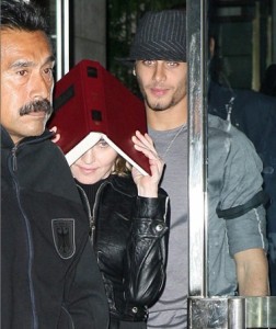 picture of Jesus Luz and Madonna as she hides her face with a copy of the book Zohar to avoid the flashes of paparazzis cameras on september 22nd 2009 in New York