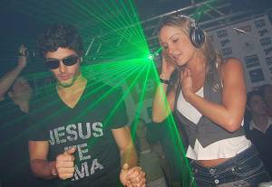 DJ Jesus Luz picture wearing a black tshirt with Jesus Te Ama imprinted on it standing next to Claudia Leitte while playing his music on stage on October 17th 2009 1