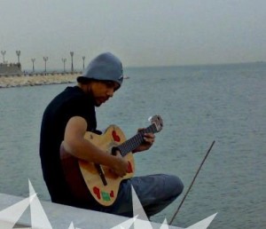 photo of Saudi student Sultan Bin Rashed playing the guitar on the shore