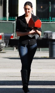 Taylor Cole candid picture while spotted walking the street recently wearing long black boots over denim trousers and a black shirt 4