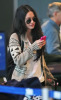 Megan Fox at the airport wearing dark-shaded sunglasses and carrying a pink cell-phone