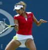 Sania Mirza during a tennis game wearing a red top and white skirt