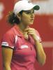 Sania Mirza during a tennis game in a light red top