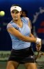 Sania Mirza during a tennis game in a blue top and a black skirt