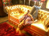 Myriam Atallah picture from her video clip resting on a golden couch