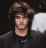 Marlon Teixeira on the runway of a modeling fashion show in a black suit