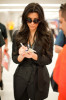 Kim Kardashian spotted arriving in Miami on February 2nd 2010 wearing a black raincoat 2