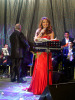 Iraqi singer Shatha Hassoun picture singing on stage in a glam red dress