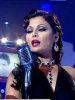 Haifa Wehbe picture during a tv appearance singing on stage in a sixty style makeup and hair wearing a black dress 2