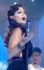 Haifa Wehbe picture during a tv appearance singing on stage in a sixty style makeup and hair wearing a black dress 7