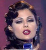 Haifa Wehbe picture during a tv appearance singing on stage in a sixty style makeup and hair wearing a black dress 1